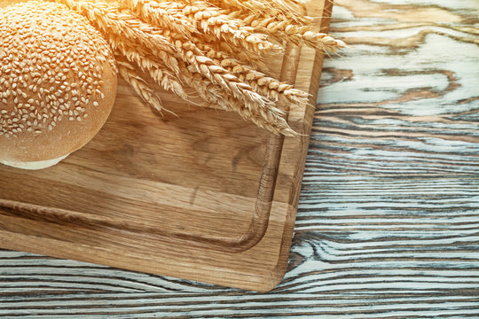 Carving board bread wheat ears on wooden surface