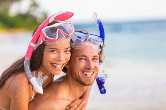 Snorkel beach summer happy couple holiday portrait. Travel vacation snorkelers smiling asian woman, caucasian man living a healthy lifestyle with diving mask at snorkeling tropical vacations.