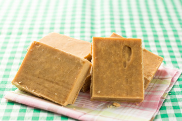 Pacoca is a candy with peanuts from Brazil. Sweet food of Festa Junina, a typical brazilian party. Snack on wicker basket and green background.