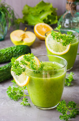 Refreshing smoothies from cucumber, green apple, fresh herbs and lemon juice in transparent glasses on the table. The concept of a healthy diet. Vegetarian menu