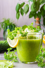 Refreshing smoothies from cucumber, green apple, fresh herbs and lemon juice in transparent glasses on the table. The concept of a healthy diet. Vegetarian menu