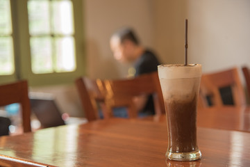 mocha coffee on table in coffee shop with man on background