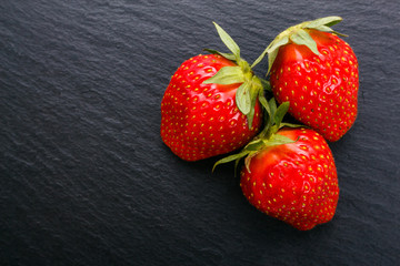 juicy fresh strawberry on a dark stone background