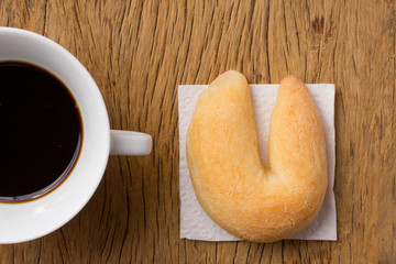 Cheese bread known as Chipa in Brazil, shaped like a horseshoe. Snack and espresso coffee on rustic wood, flat design.