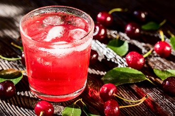 Fresh cherries and ice cherry fruit drink on wood