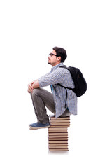 Young student sitting on top of book stack on white