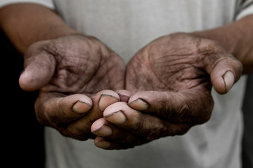 The poor old man's hands beg you for help. The concept of hunger or poverty. Selective focus. Poverty in retirement. Alms