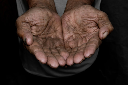 The poor old man's hands beg you for help. The concept of hunger or poverty. Selective focus. Poverty in retirement. Alms