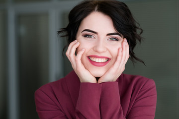 emotion face. happy smiling joyful jolly woman holding head in hands. young beautiful brunette girl...