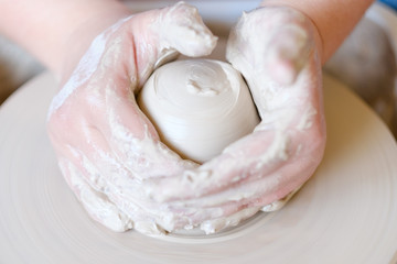 handmade hobby pottery courses. master class at workshop. potter forming clay on turning wheel