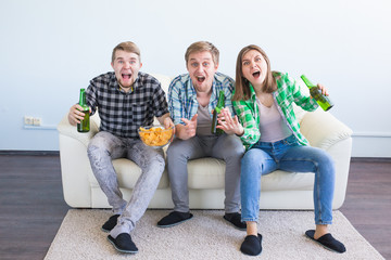 Happy friends or football fans watching soccer on tv and celebrating victory. Friendship, sports and entertainment concept