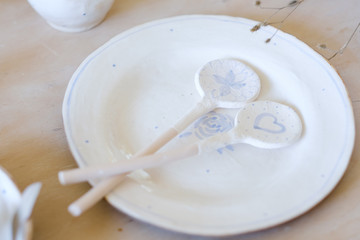 pottery handcraft hobby. exquisite handmade craft white clay plate and spoons