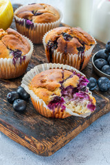 Homemade blueberry and lemon muffins on wooden board