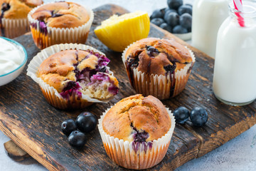 Homemade blueberry and lemon muffins on wooden board