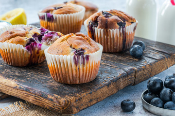 Homemade blueberry and lemon muffins on wooden board