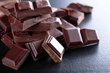 Broken chocolate pieces on black background.