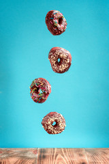 Donuts on blue background. Pile of fresh homemade donuts with icing and colorful sprinkles. 