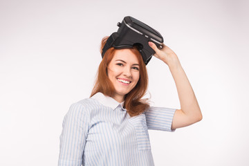 Happy young red-haired woman using a virtual reality headset
