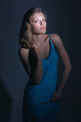Fototapeta premium Studio portrait of young beautiful sensual woman in blue dress.