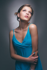 Fototapeta premium Studio portrait of young beautiful sensual woman in blue dress.