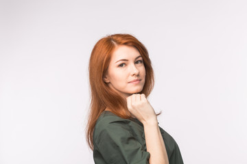 Smiling red-haired beautiful woman with hand on her chin