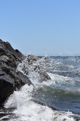 Ocean waves crashing on rocks beside pebble beach