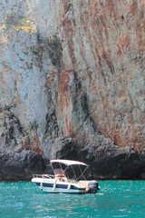 A boat in front of Castro rocky coast, Salento, Apulia, Italy