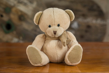 Cute teddy bear on a wooden table.