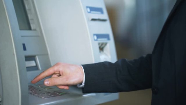 Tourist entering pin code and receiving Japanese yen, banking for travelers
