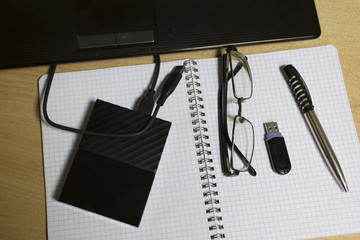 office workstation with laptop and hard drive and pencil