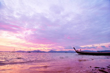 Obraz premium Travel in Thailand. Colorful landscape with sea beach, traditional longtail boat over beautiful sunset background.