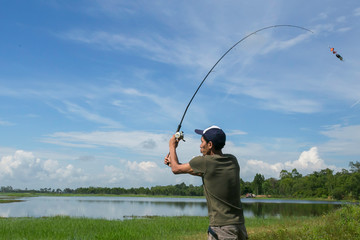Asian man fishing in the reservoir