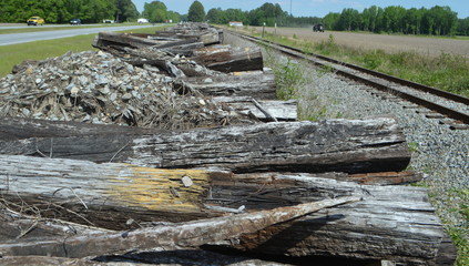 Fototapeta na wymiar Stack of old rail ties by railroad tracks