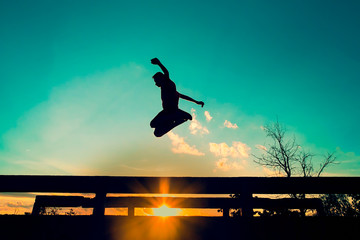 Man jumping Bridge at sunset