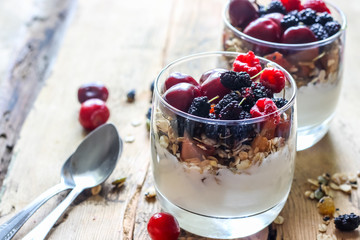 Granola with yogurt and berries in a glass. Delicious healthy American food for breakfast. Traditional US snack. Selective focus