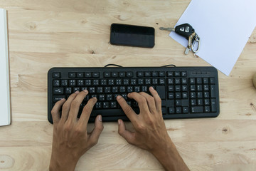 hands on the keyboard and geese and ducks smartphones, car keys placed on a desk. © tinny_12345