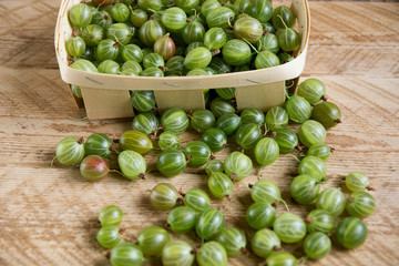 gooseberries in a basket on a wooden background