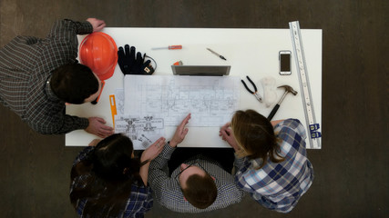 Group of young architects working on drawings