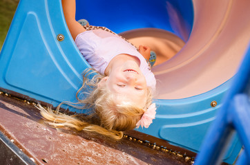 little lovely girl playing in playground up side down