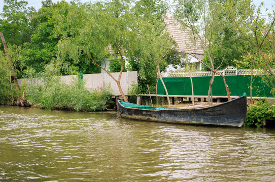 Danube river and fishing boat near the shore on a summer day. Vilkovo, Ukraine