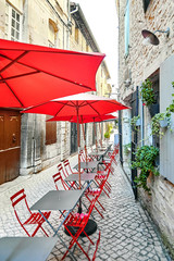 Summer street cafe with red umbrellas and chairs