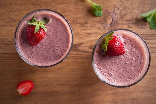 Two Glasses Of Chocolate Strawberry Milkshake Or Cocktail On Wooden Table.  Strawberry Chocolate Smoothie With Berries. Healthy Drinks. Overhead, Horizontal