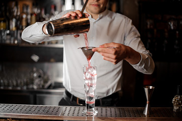 Barman making a fresh and cold strawberry mojito summer cocktail
