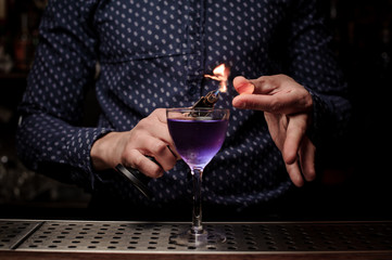 Bartender making a sweet and fresh purple summer cocktail with a smoke note