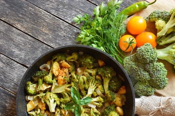 fresh broccoli and orange tomatoes, cooked broccoli with mushrooms, carrots and potatoes. organic and vegan food kitchen 