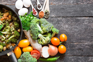fresh broccoli and orange tomatoes, cooked broccoli with mushrooms, carrots and potatoes. organic and vegan food kitchen 