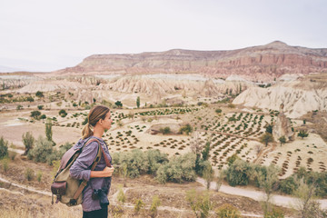 Travel concept. Travelling young woman with backpack enjoying mountains view.