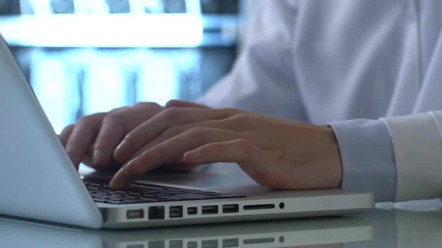 Lab expert typing medical report laptop, entering data record, research results