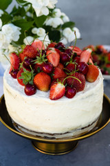 Cake with berries on a summer background. Birthday and summer concept.