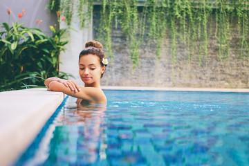 Swimming pool spa retreat relaxation. Relaxing woman lenjoying serenity in summer holiday travel vacation at resort hotel.